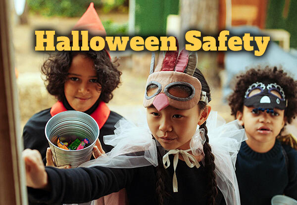 Halloween Safety. Three children in Halloween costumes ring the doorbell to get candy.